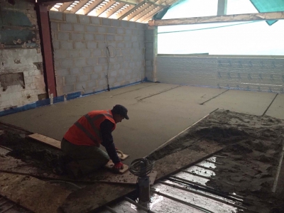 floor screed being levelled by a builder, house floor screeder